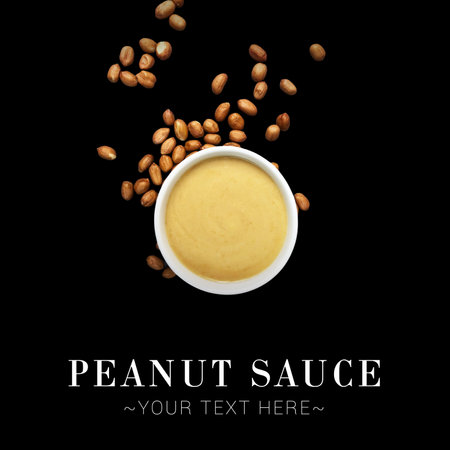 Top view of bowl with Japanese traditional peanut sauce with peanuts scattered on background. Ready...