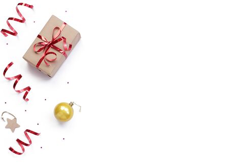 minimalistic christmas composition. Wrapped gift with a red bow on a white background with Christmas decorations, golden shiny ball, wrapping ribbon, sparkles stars. top view, copy space, happy new year conceptの写真素材
