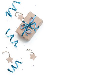 minimalistic christmas composition. Wrapped gift with a blue bow on a white background with Christmas decorations, wrapping ribbon spirals, sparkles stars. top view, copy space, happy new year conceptの写真素材