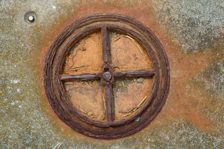 Old rusted iron  wheel,  pipe in concreteの写真素材