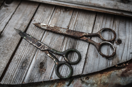 Two aged rusty scissors on wooden boardsの写真素材
