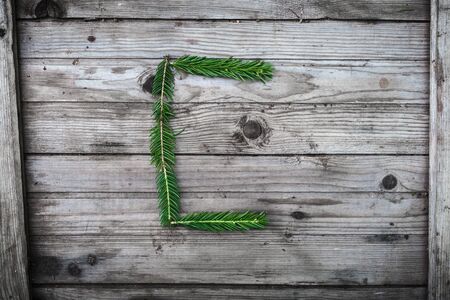 Letter from fir tree branches on aged wooden boardsの写真素材