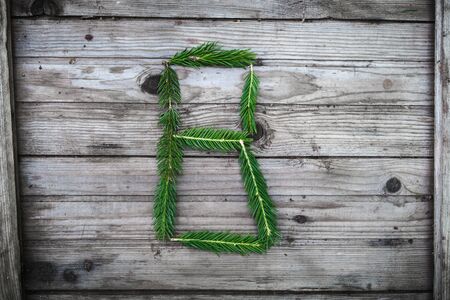 Letter from fir tree branches on aged wooden boardsの写真素材