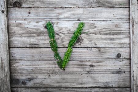 Letter from fir tree branches on aged wooden boardsの写真素材
