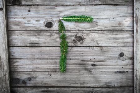 Letter from fir tree branches on aged wooden boardsの写真素材