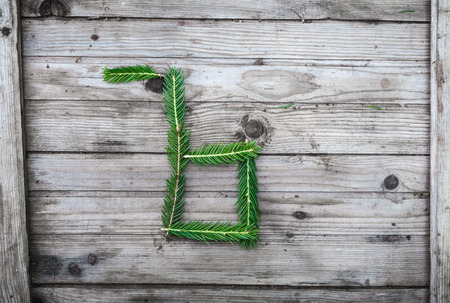 Letter from fir tree branches on aged wooden boardsの写真素材