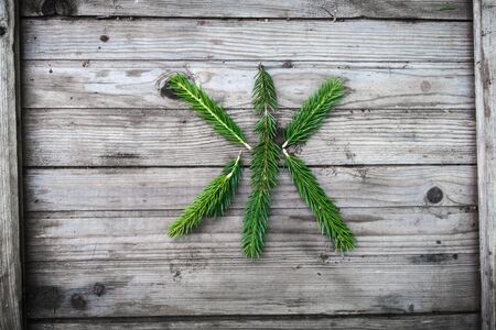 Letter from fir tree branches on aged wooden boardsの写真素材