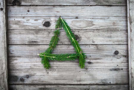 Letter from fir tree branches on aged wooden boardsの写真素材