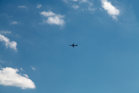 Airplane in the blue sky with cloudsの写真素材