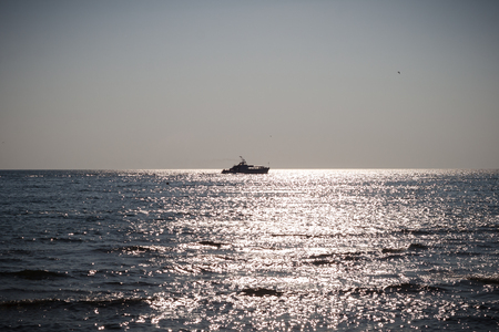 The boat sails across the sea on the horizonの写真素材