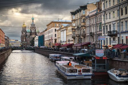 Saint Petersburg, Russia, August, 7, 2017 - View of the Church of the Savior on Spilled Blood  (Spas na Krovi) from the  Griboyedov Channel. Water walking vehicles. Storm clouds.のeditorial素材