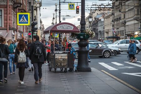 Saint Petersburg, Russia, August, 7, 2017 - Nevsky prospect. People walking down the street. Mobile stand with roasted chestnuts. Cars.のeditorial素材