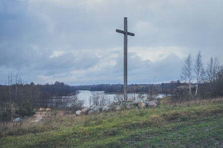 Peasant wooden cross on the mountain near the river bank, lake. The Catholic cross. The Crucifixion.の写真素材