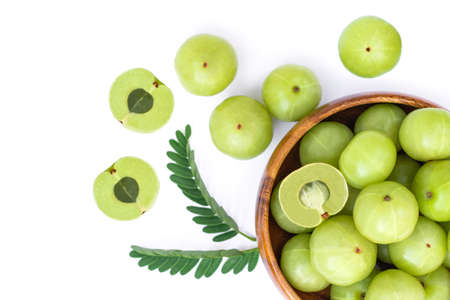 Closeup Indian gooseberry fruits ( phyllanthus emblica, amla ) in wooden bowl with green leaf and...