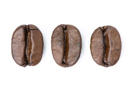 Dark brown roasted coffee beans isolated on white background. Macroの写真素材