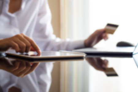 Young woman shopping by using digital tablet pc and credit card at home. Online shopping and payment...