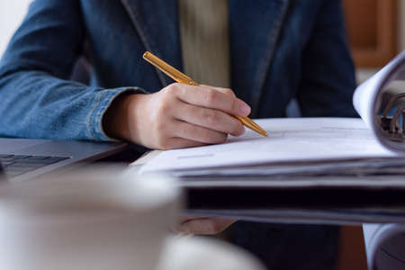 Business woman hand proof and sign a contract, work with laptop computer at office.