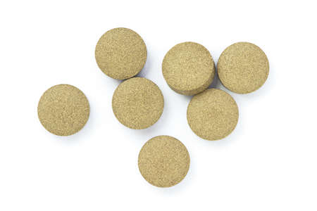 Green natural herbal medicine tablet pills isolated on white background. Top view. Flat lay.の写真素材