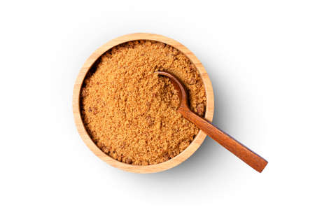 Brown unrefined cane sugar in wooden bowl with spoon isolated on white backgroundの写真素材