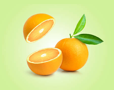 Fresh orange fruit with slice and green leaf isolated on green color background.の写真素材