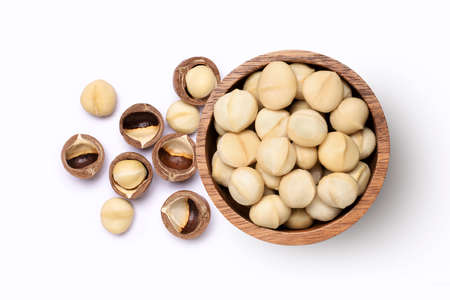 Macadamia nuts in wooden bowl isolated on white background. Top view.の写真素材