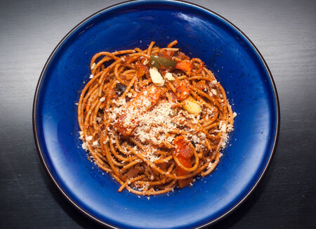 vegetarian  garlic onion carrot capsicum wholemeal spaghetti with grated cheese garlic onion carrot in blue deep dishの写真素材