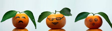 Oranges with leaves show us some faces.の写真素材