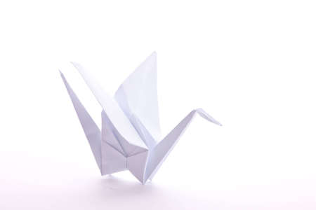 White paper-folded Origami crane, isolated on whiteの写真素材