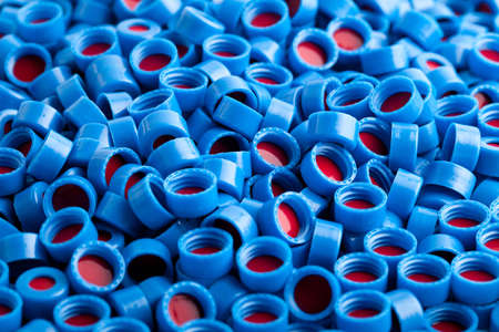 Background of blue and red carved plastic caps for chromatographic vials の写真素材