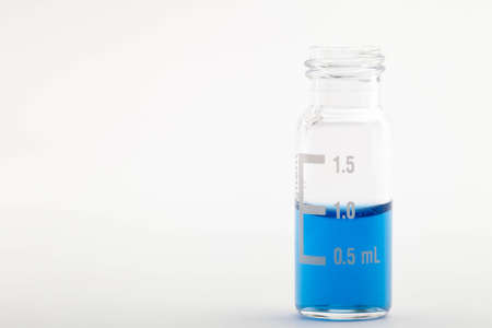 Single chromatographic glass vial filled with one milliliter of blue liquid  Isolated on white