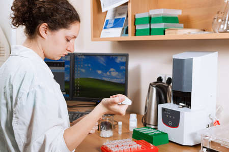 Female researcher in a lab performs sample preparation for DNA electrophoresisの写真素材