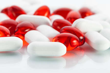Extreme close-up view of vitamin pills  white tablets and red vitamin E capsulesの写真素材