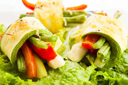Fresh vegetable rolls with young zucchini, tomatoes, paprika, beans, celery and cheeseの写真素材