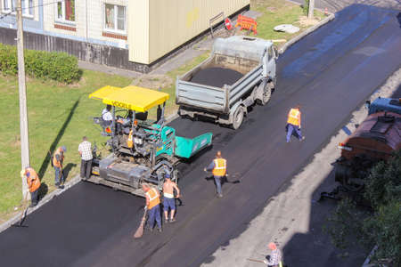 Road workers producing related work. Leningrad region, Russia - 15 June, 2015. Landscaping and asphalting of yards.のeditorial素材