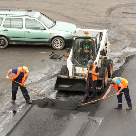 Work to level asphalt. Leningrad region, Russia - 15 June, 2015. Landscaping and asphalting of yards.のeditorial素材