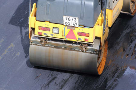 Road vehicle compacted asphalt. Leningrad region, Russia - 15 June, 2015. Landscaping and asphalting of yards.のeditorial素材