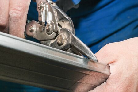 Cutting resistant plasterboard on metal scissors.の写真素材