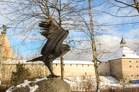 Bronze eagle on a background of the old fortress. Staraya Ladoga, Russia - 23 February, 2016. Tourist places in the great ancient route from the Vikings to the Greeks.Staraya Ladoga fortress. Gold ring of Russia.のeditorial素材