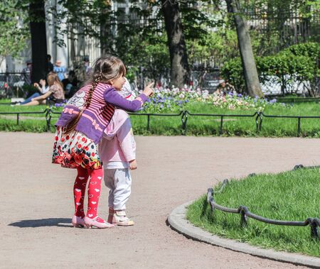 Children in flower beds. Vacationers people on the lawns and gardens in the city.のeditorial素材
