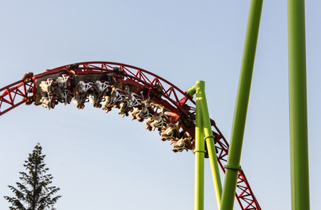 People on a loop ride upside down. Amusement and extreme rides for teenagers and adults.のeditorial素材