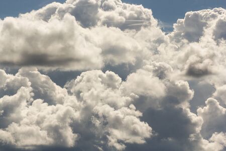 Cumulus and cirrus clouds illuminated by the sun.