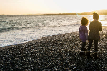 Two girls by the sea at sunset. People and tourists having a rest on the Cote d'Azur.の写真素材
