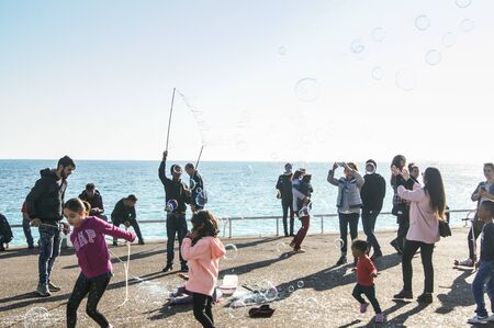 People have fun with soap bubbles. People and tourists having a rest on the Cote d'Azur.のeditorial素材