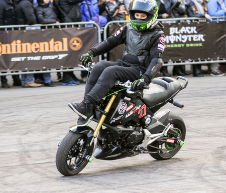 Doing tricks on a bike. Sports motorcycle show of bikers on the open area.のeditorial素材