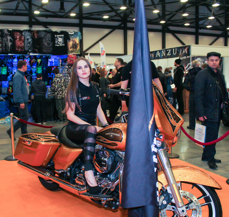 A girl is posing on a big motorcycle. Models on motorcycles presented at the motor show.のeditorial素材