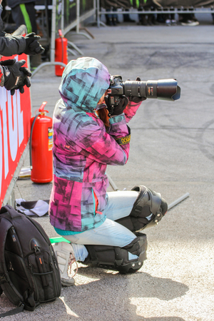 Girl sports photographer. Girl sports photographer. Sports motorcycle show of bikers on the open area.の写真素材