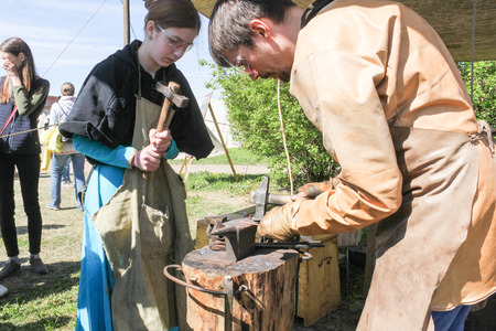 Blacksmith at the small anvil. Festival of the Legends of the Norwegian Vikings in St. Petersburg Petersburg.のeditorial素材