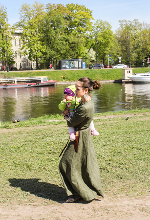 A woman with a child on the beach. Festival of the Legends of the Norwegian Vikings in St. Petersburg Petersburg.のeditorial素材