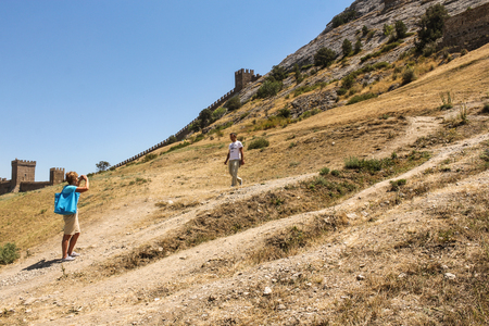 People are photographed near the fortress. Genoese ancient fortress near the city of Sudak.のeditorial素材