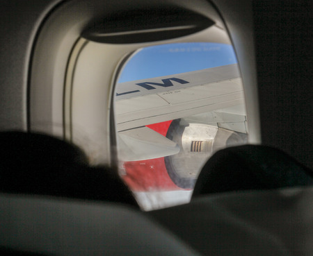 The wing in the airplane window. People traveling by air lines.の写真素材